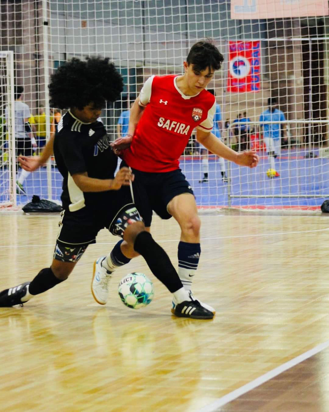 Two young men working for control over the futsal ball