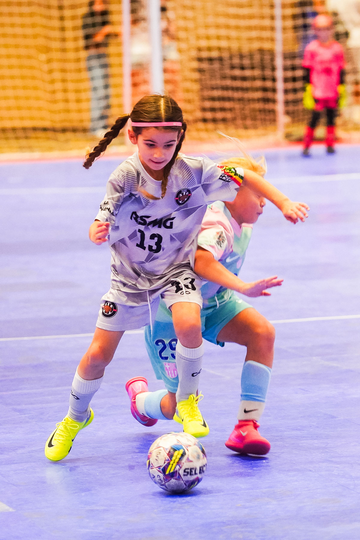 Young girl taking possession of a futsal ball from another girl